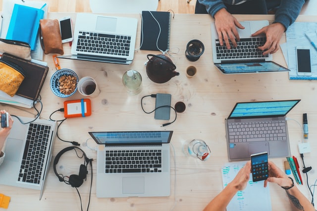 People working at laptops on a desk