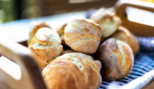Fresh bread rolls on a wooden tray